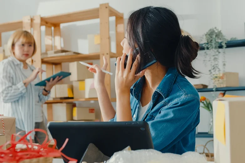 young-asian-businesswoman-wearing-face-mask-using-mobile-phone-receiving-purchase-order-and-checking-product-on-stock-work-at-home-office (1)